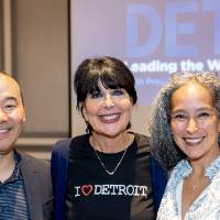 President Mantella standing between two other event attendees, smiling for camera